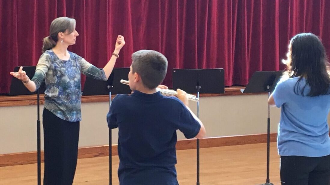 Flute-a-rama co-director Melissa Lindon conducts Takoma Park students in dress rehearsal