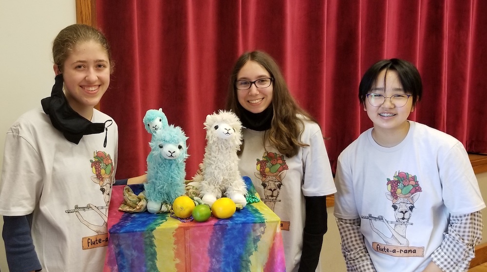 students wearing Flute-a-rama camp t-shirts pose with fruit and llama mascots